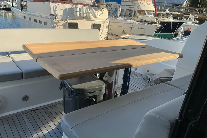 Slide: The Image of 2019 Sunseeker Predator 50 yacht interior with wooden table and cushioned seating. - 58