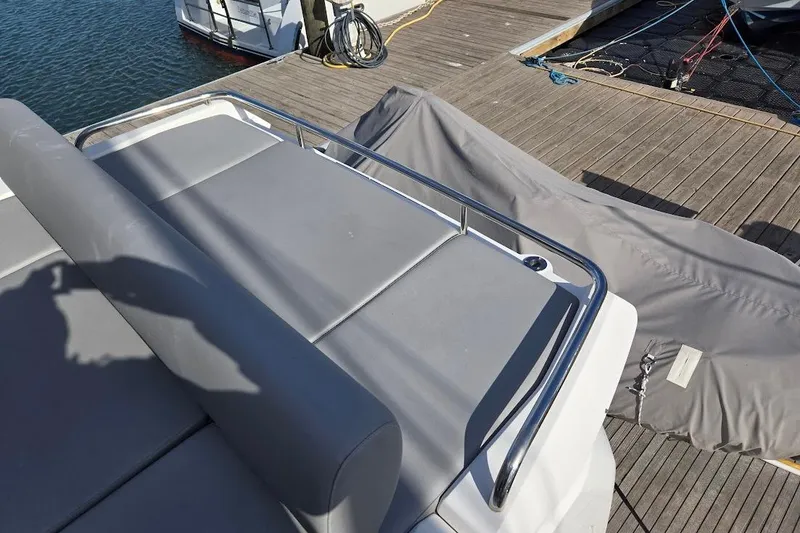 Slide: The Image of Sunseeker Predator 50 yacht deck, 2019 model, with gray seating and dock view. - 60