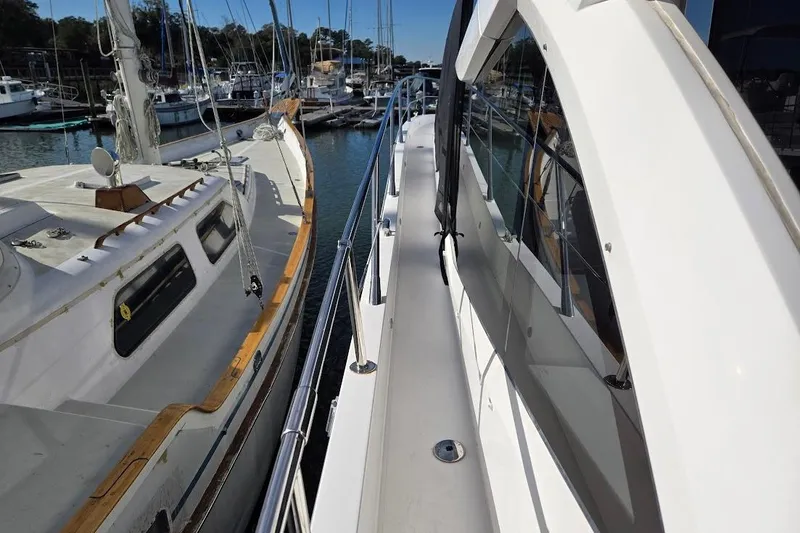 Slide: The Image of 2019 Sunseeker Predator 50 yacht docked beside another boat in a marina. - 63