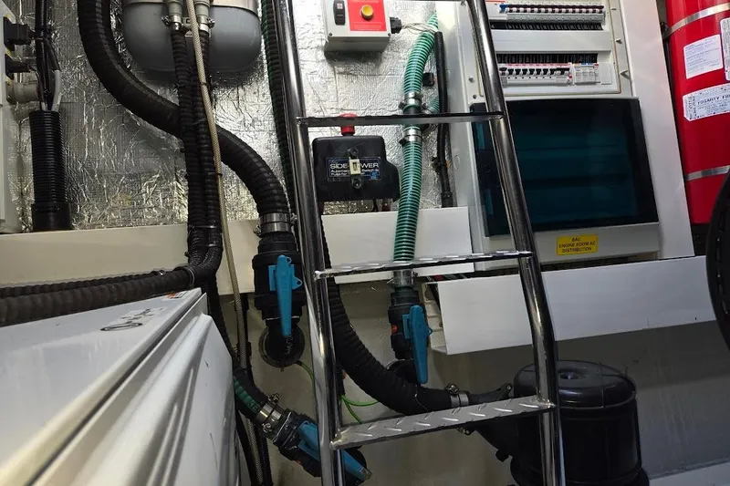 Slide: The Image of Engine room of 2019 Sunseeker Predator 50 yacht, featuring pipes, ladder, and control panels. - 67