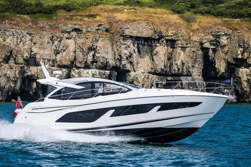 Slide: The Image of 2019 Sunseeker Predator 50 yacht cruising near rocky cliffs on a sunny day. - 89