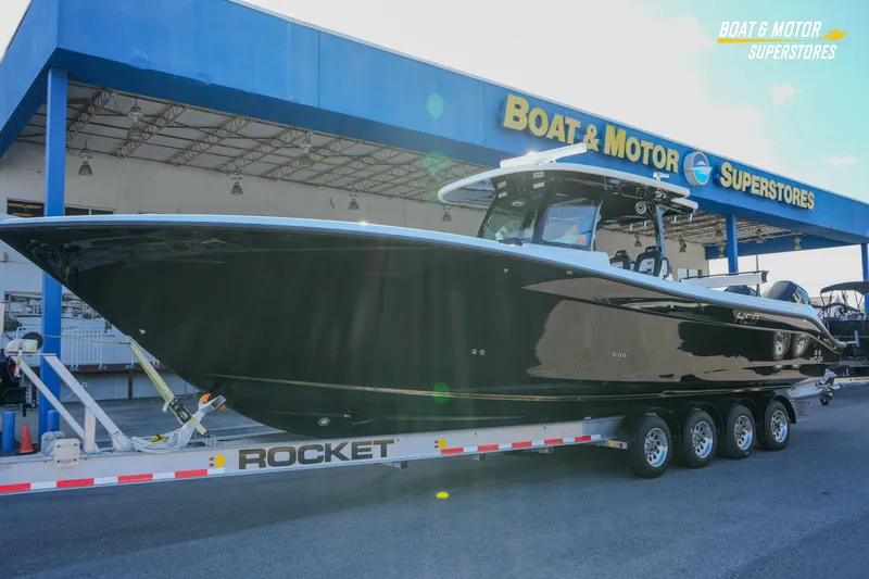 Slide: The Image of 2023 HCB 39 Speciale boat cruising on a scenic river with lush greenery. - 2