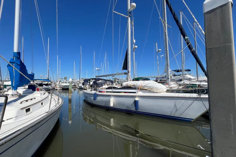 Slide: The Image of 1989 Catalina 42 MkII sailboat docked at marina under clear blue sky. - 2