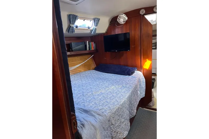 Slide: The Image of Interior view of a 1989 Catalina 42 sailboat, featuring a wooden door and flooring. - 32