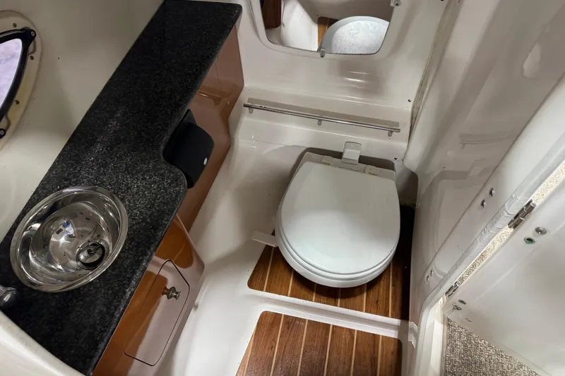 Slide: The Image of 2008 Chaparral 284 Sunesta boat bathroom with sink, toilet, and wood flooring. - 13