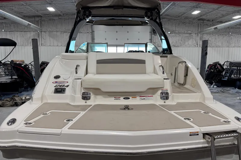 Slide: The Image of 2008 Chaparral 284 Sunesta boat interior with seating and storage, displayed in a showroom. - 5