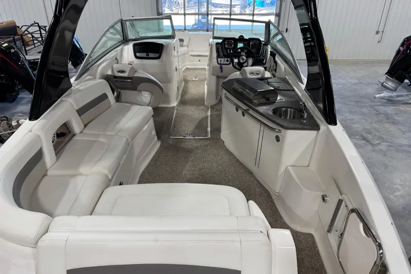 Slide: The Image of 2008 Chaparral 284 Sunesta boat interior with seating, helm, and kitchenette. - 6