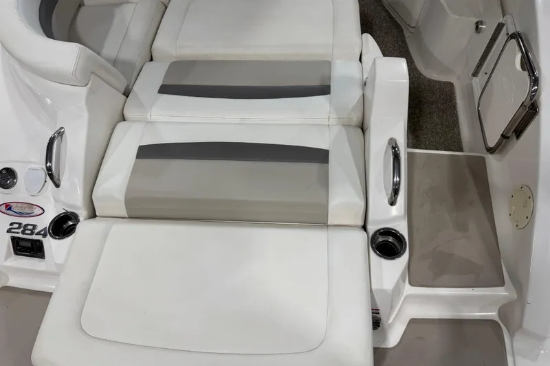 Slide: The Image of 2008 Chaparral 284 Sunesta boat interior with white and gray seating, cup holders, and step. - 7