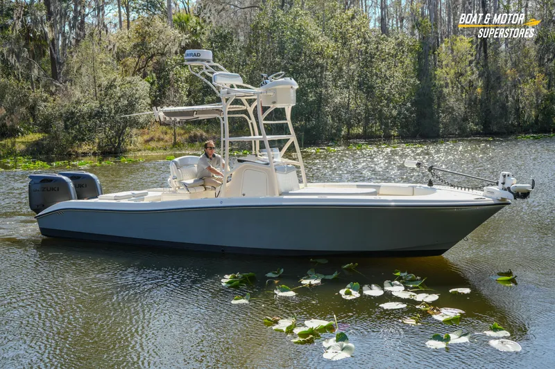The Image of Young 27 boat from 2016 on a serene lake with lush greenery. - 0