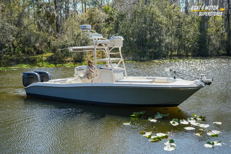 Slide: The Image of A 2016 Young 27 boat cruising on a serene lake surrounded by lush greenery. - 2