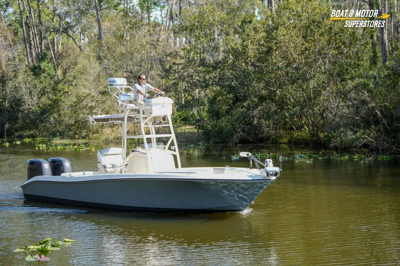 Slide: The Image of Man steering 2016 Young 27 boat on a calm river, surrounded by lush greenery. - 31