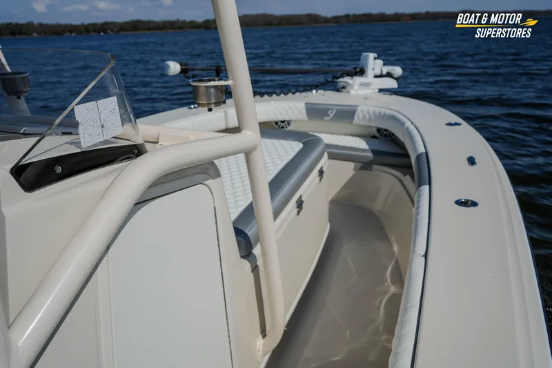 Slide: The Image of Interior view of a 2016 Young 27 boat on a lake, featuring seating and railing. - 22