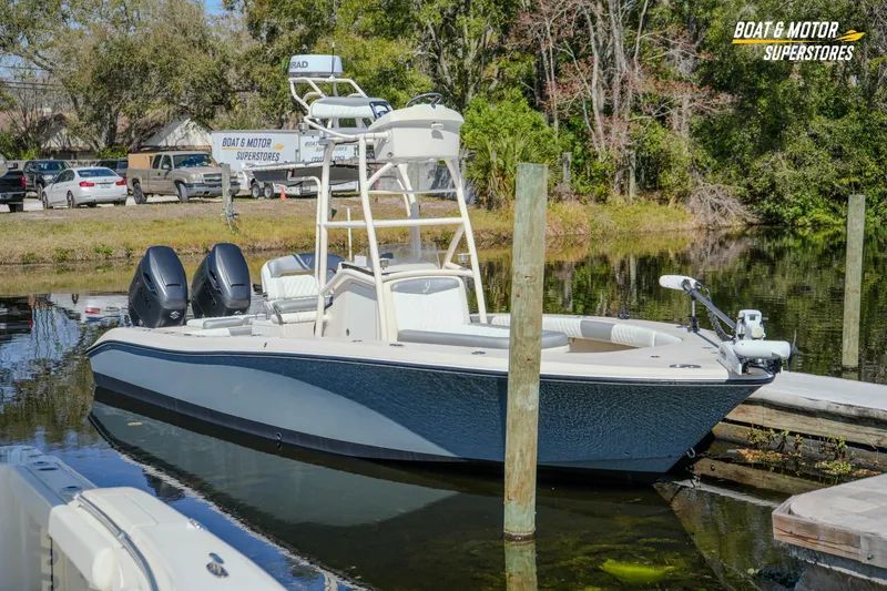 Slide: The Image of 2016 Young 27 boat docked at a serene lakeside, featuring dual engines. - 6