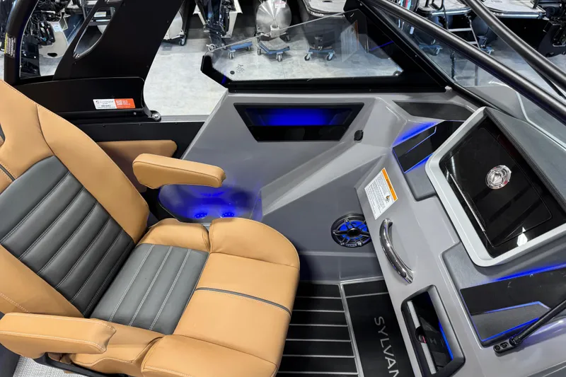Slide: The Image of 2026 Sylvan G5 boat interior with tan and gray seating, modern dashboard, and blue LED lighting. - 12