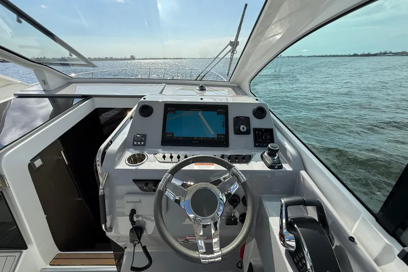 Slide: The Image of 2025 Beneteau Gran Turismo 32 cockpit with modern navigation system and steering wheel. - 14