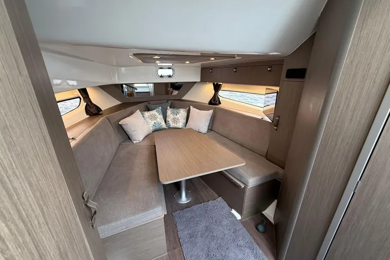 Slide: The Image of Luxurious interior of 2025 Beneteau Gran Turismo 32 yacht with cozy seating and table. - 15
