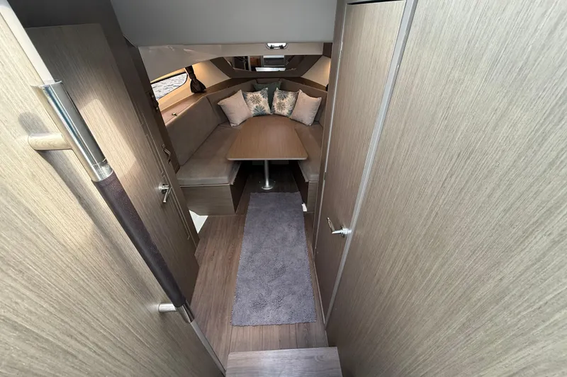 Slide: The Image of Interior of 2025 Beneteau Gran Turismo 32, featuring cozy seating and modern wood finish. - 16