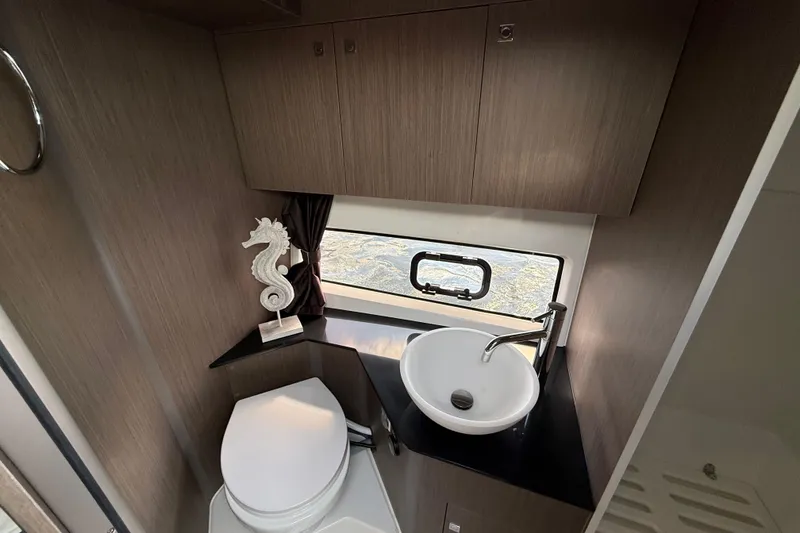 Slide: The Image of 2025 Beneteau Gran Turismo 32 bathroom with modern sink, toilet, and seahorse decor. - 19