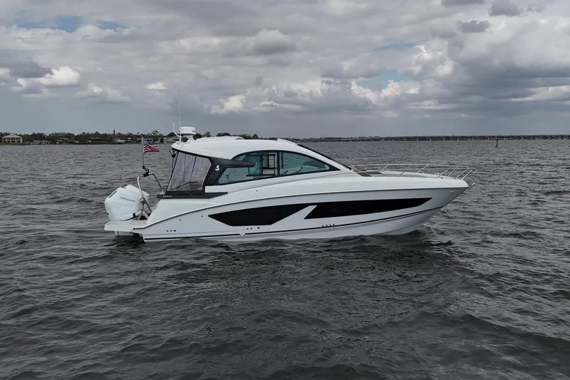 Slide: The Image of 2025 Beneteau Gran Turismo 32 yacht on open water under cloudy sky. - 2