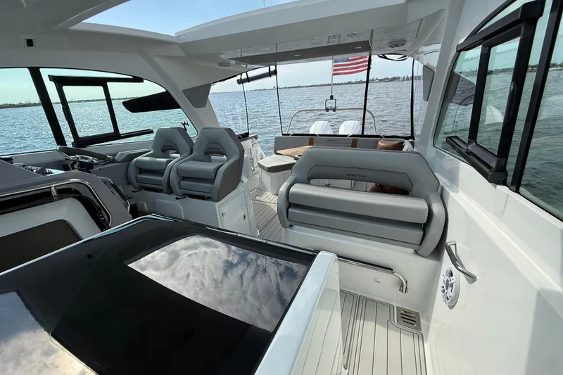 Slide: The Image of 2025 Beneteau Gran Turismo 32 interior with modern seating and open water view. - 21