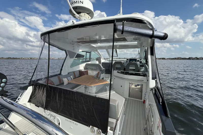 Slide: The Image of 2025 Beneteau Gran Turismo 32 yacht interior with seating and table, on calm water. - 7