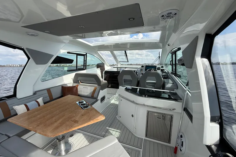 Slide: The Image of 2025 Beneteau Gran Turismo 32 interior with modern seating and wooden table on open water. - 8