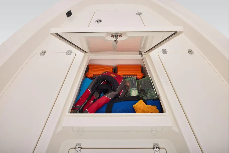 Slide: The Image of Open storage compartment on 2026 Mako 24 APEX boat with safety gear and equipment. - 14