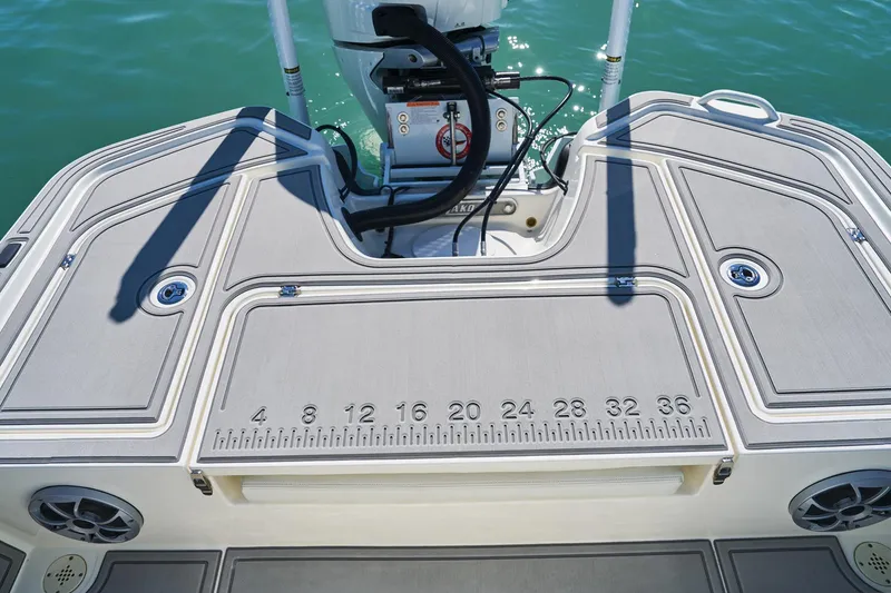 Slide: The Image of 2026 Mako 24 APEX boat deck with ruler, motor, and storage compartments. - 71