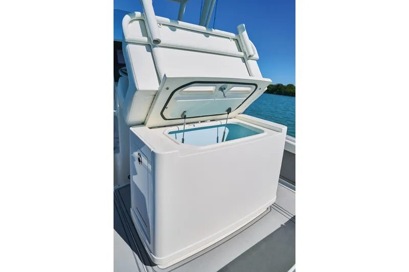 Slide: The Image of 2026 Mako 24 APEX boat with open storage compartment on deck. - 72