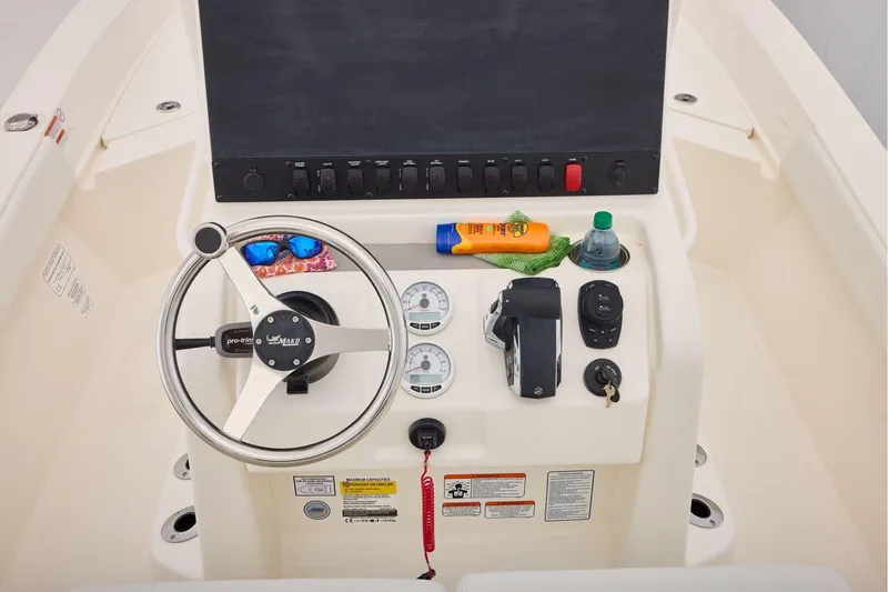 Slide: The Image of 2026 Mako 24 APEX boat console with steering wheel, controls, and accessories. - 30