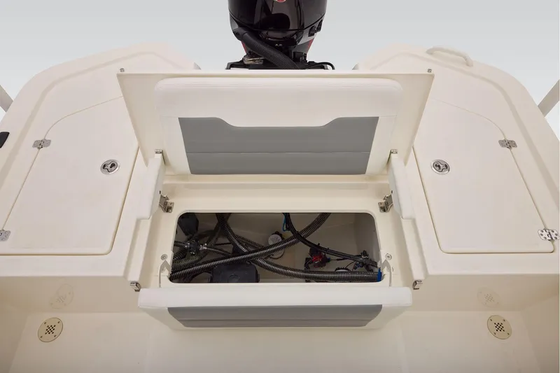 Slide: The Image of Open storage compartment on 2026 Mako 24 APEX boat, showing internal wiring and components. - 43