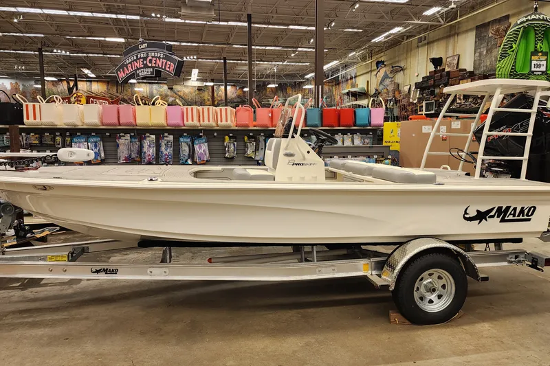 The Image of 2026 Mako 18 Pro Skiff boat displayed indoors on a trailer. - 0