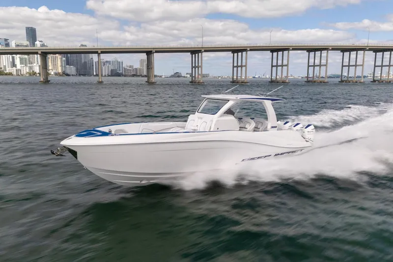 Slide: The Image of 2026 Deep Impact 399 Sport boat cruising on water near a bridge, city skyline in background. - 2