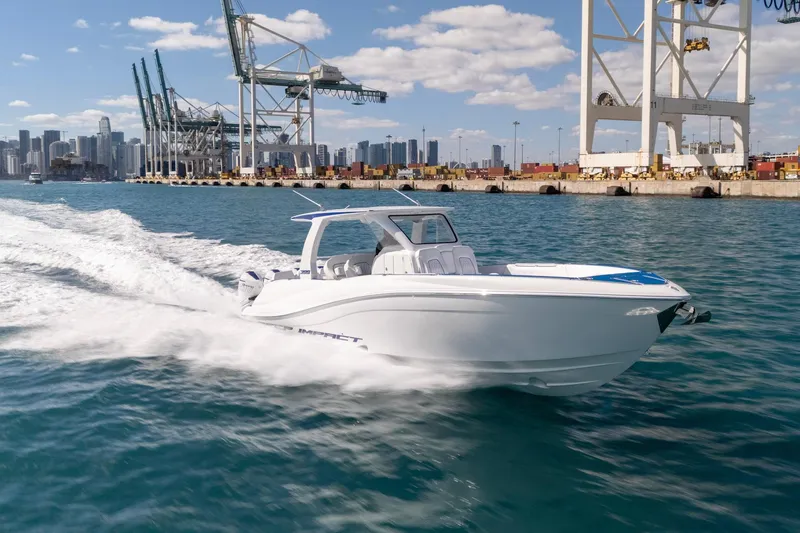 Slide: The Image of 2026 Deep Impact 399 Sport boat cruising near industrial port with city skyline. - 7