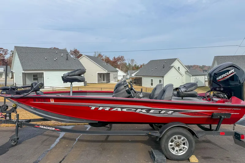 The Image of 2023 Tracker Pro Team 175 TXW Tournament Edition boat on trailer, parked in residential area. - 1