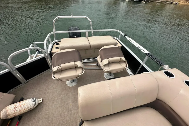 Slide: The Image of 2019 SunCatcher SF 22 XP3 pontoon boat interior with beige seating on a calm lake. - 12