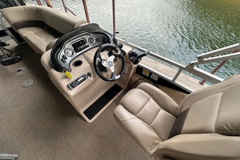 Slide: The Image of 2019 SunCatcher SF 22 XP3 boat interior with steering console and seating by the water. - 19