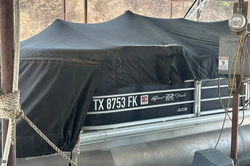 Slide: The Image of 2019 SunCatcher SF 22 XP3 pontoon boat on a calm lake with wooded shoreline. - 4