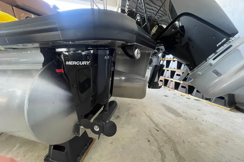 Slide: The Image of 2026 Harris Crowne SL 250 pontoon boat with Mercury outboard motor in a storage area. - 10