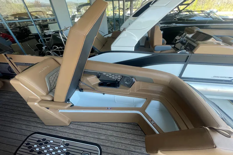 Slide: The Image of 2026 Harris Crowne SL 250 boat interior with tan seating and storage compartment open. - 23