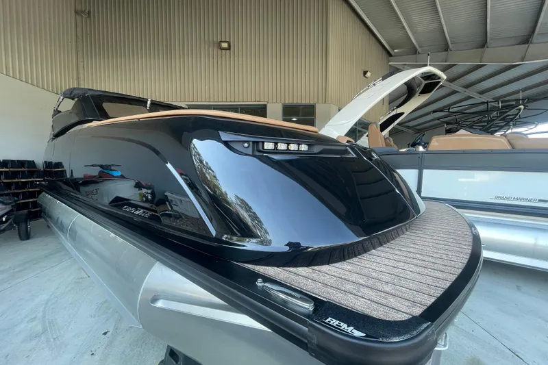 Slide: The Image of 2026 Harris Crowne SL 250 pontoon boat in a showroom, sleek black design. - 28