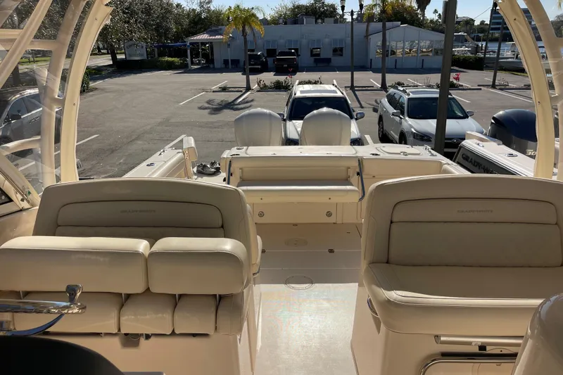 Slide: The Image of 2019 Grady-White Freedom 325 boat interior with seating and parked cars in the background. - 13