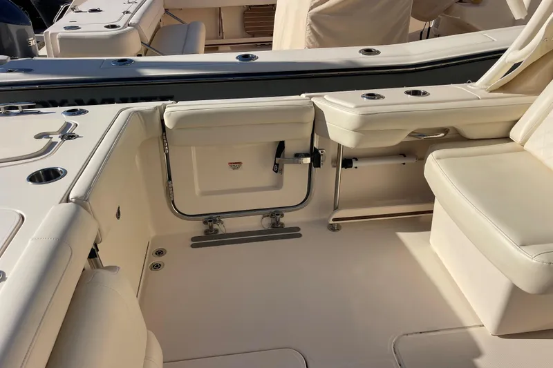 Slide: The Image of 2019 Grady-White Freedom 325 boat interior with beige seating and cup holders. - 14