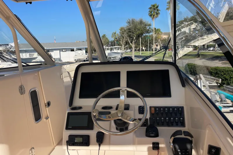 Slide: The Image of 2019 Grady-White Freedom 325 boat dashboard with steering wheel and control panels. - 5