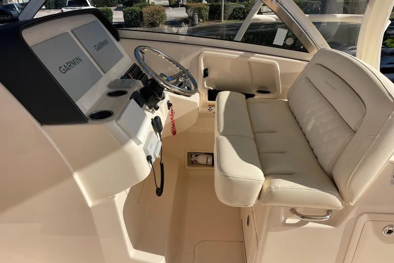 Slide: The Image of 2019 Grady-White Freedom 325 boat interior with Garmin displays and plush seating. - 6