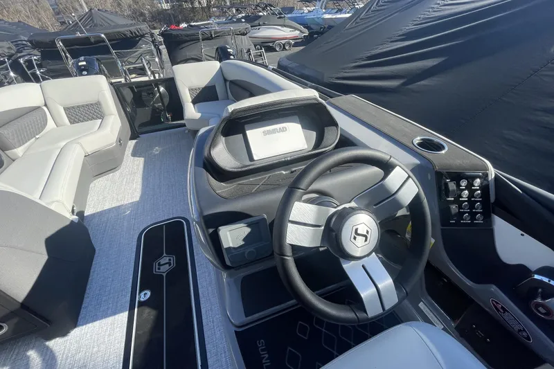 Slide: The Image of 2026 Harris Sunliner 230 boat interior with modern steering wheel and seating. - 18