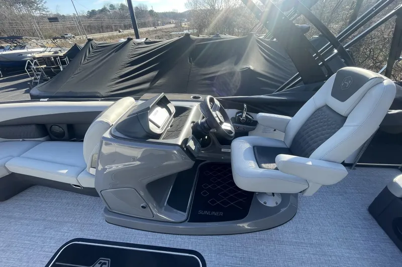 Slide: The Image of 2026 Harris Sunliner 230 boat interior with captain's chair and control console. - 4
