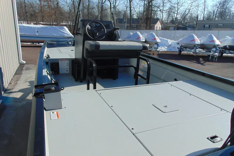 Slide: The Image of 2026 Crestliner 1760 Retriever SC boat interior with console and seating, parked outdoors. - 8