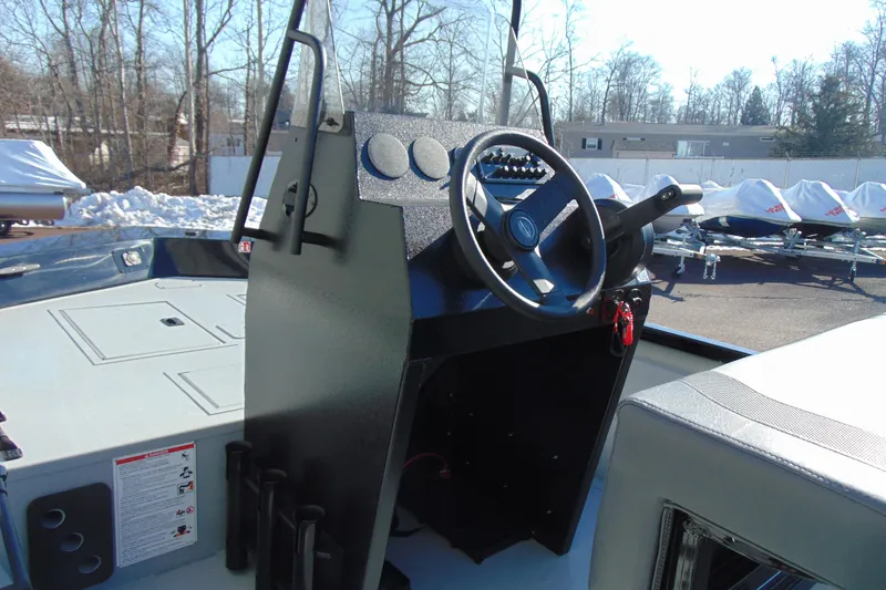 Slide: The Image of 2026 Crestliner 1760 Retriever SC boat console with steering wheel, outdoors in winter setting. - 9
