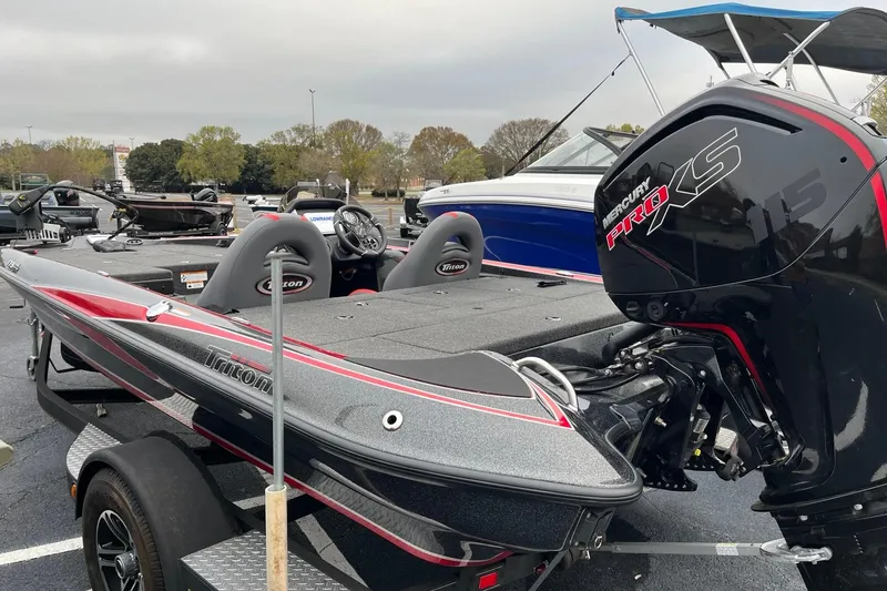 Slide: The Image of 2024 Triton 179 TrX bass boat with Mercury Pro XS engine in a parking lot. - 3